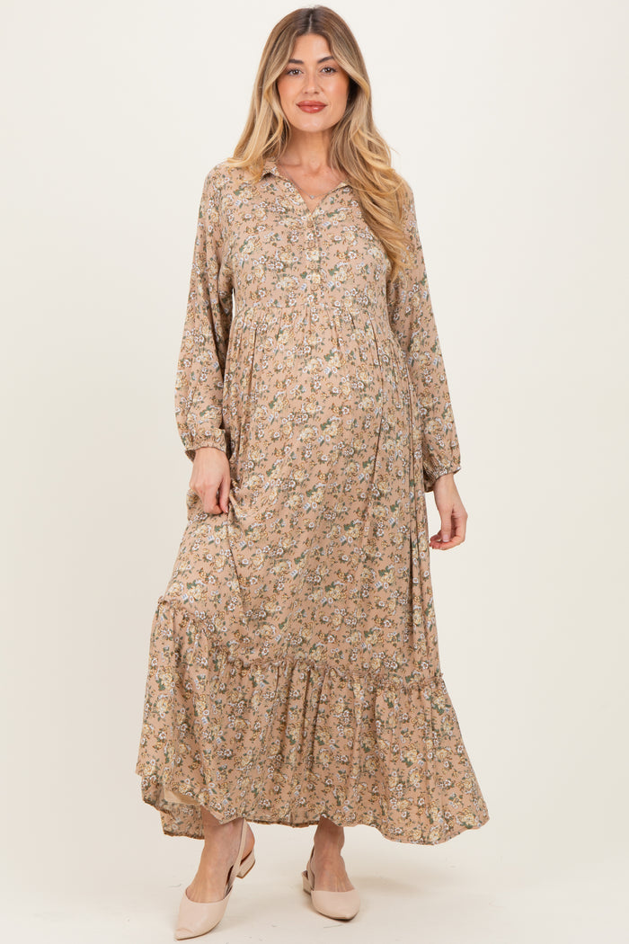 woman wearing a floral maternity dress with long sleeves and a tiered hem, showcasing her baby bump