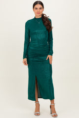 woman wearing a dark green long sleeve glitter dress with side ruching and a front slit, posing elegantly