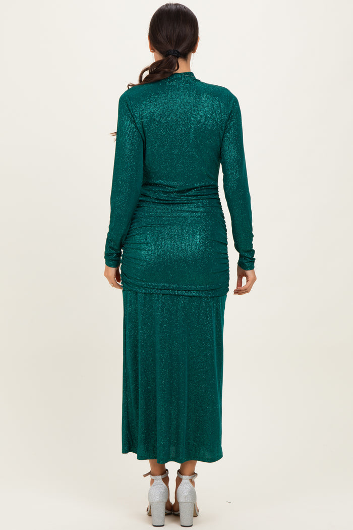 woman wearing a dark green long sleeve glittery maxi dress, view from the back showing ruching details