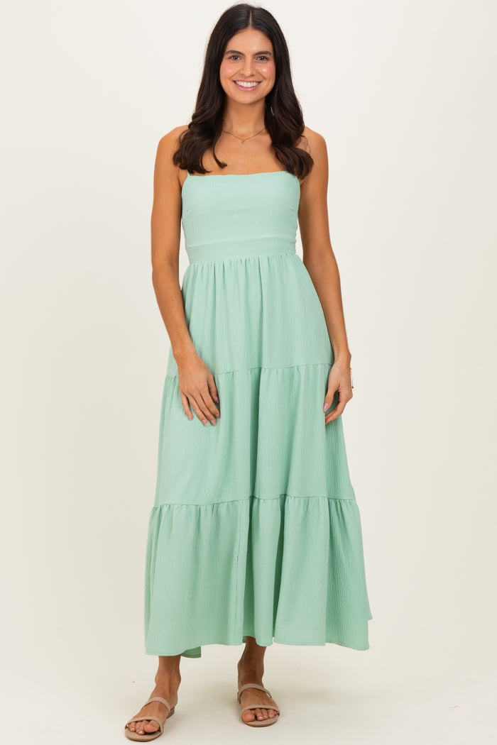 woman wearing a mint green strapless tiered maxi dress with a flowy silhouette