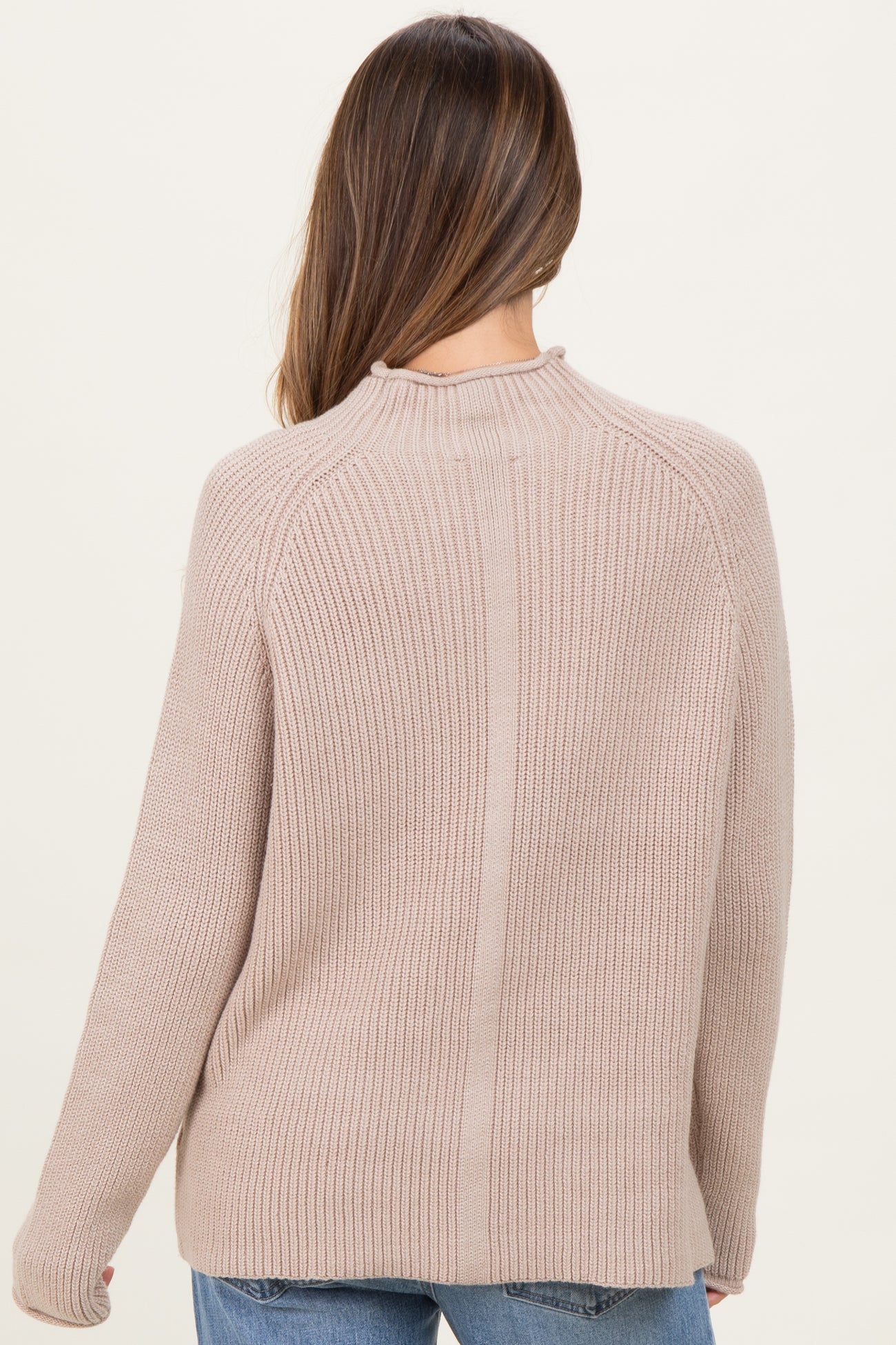woman wearing a beige ribbed maternity sweater, view from the back