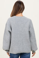 woman wearing a gray ribbed maternity sweater with balloon sleeves seen from the back