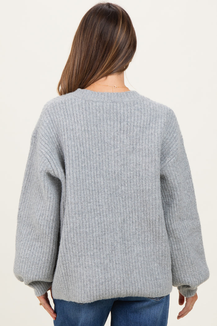 woman wearing a gray ribbed maternity sweater with balloon sleeves seen from the back