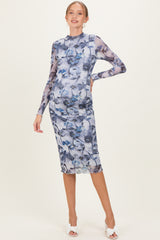 woman wearing a floral print long sleeve maternity dress with a fitted silhouette and visible baby bump