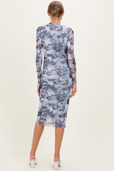 woman wearing a fitted long sleeve maternity dress in a floral blue print, showing a baby bump