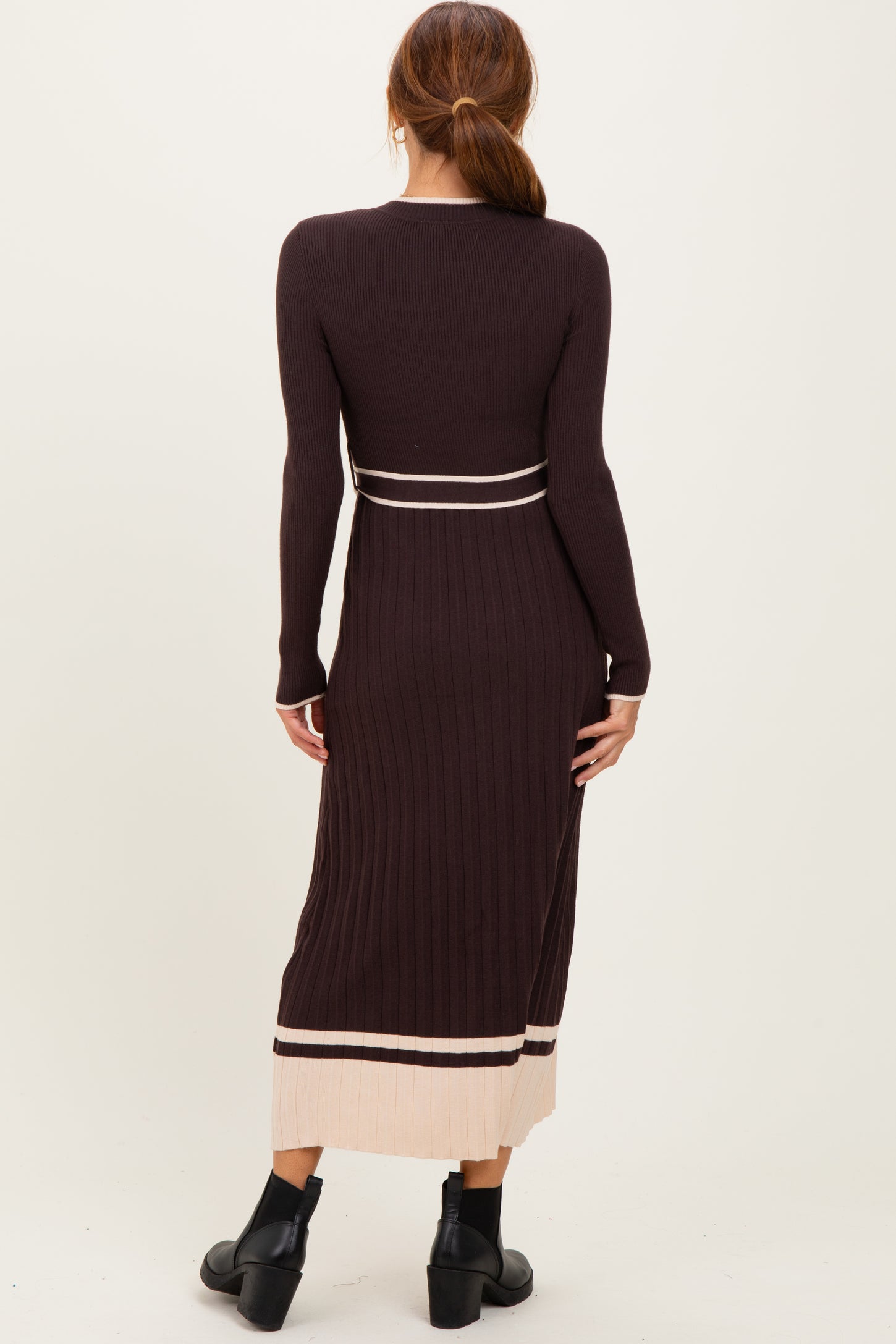 woman wearing a long sleeve ribbed brown midi dress with cream accents and a fitted silhouette.