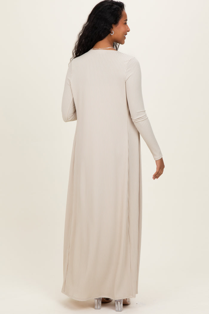 woman wearing a long beige ribbed maternity dress with long sleeves, showing the back view