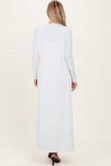 woman wearing a long white ribbed maxi dress with long sleeves, shown from the back