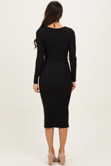 woman wearing a black long sleeve midi dress, viewed from the back