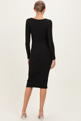 woman wearing a black long sleeve maternity dress, showing a fitted silhouette from the back