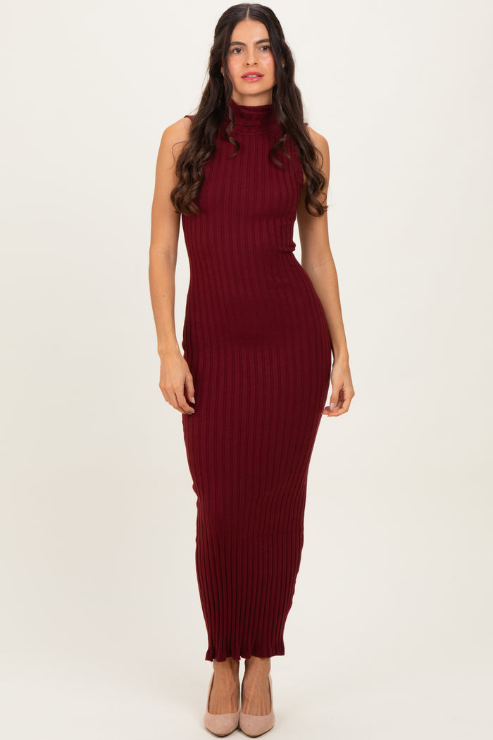 woman wearing a burgundy ribbed sleeveless maxi dress with a high neckline and fitted silhouette