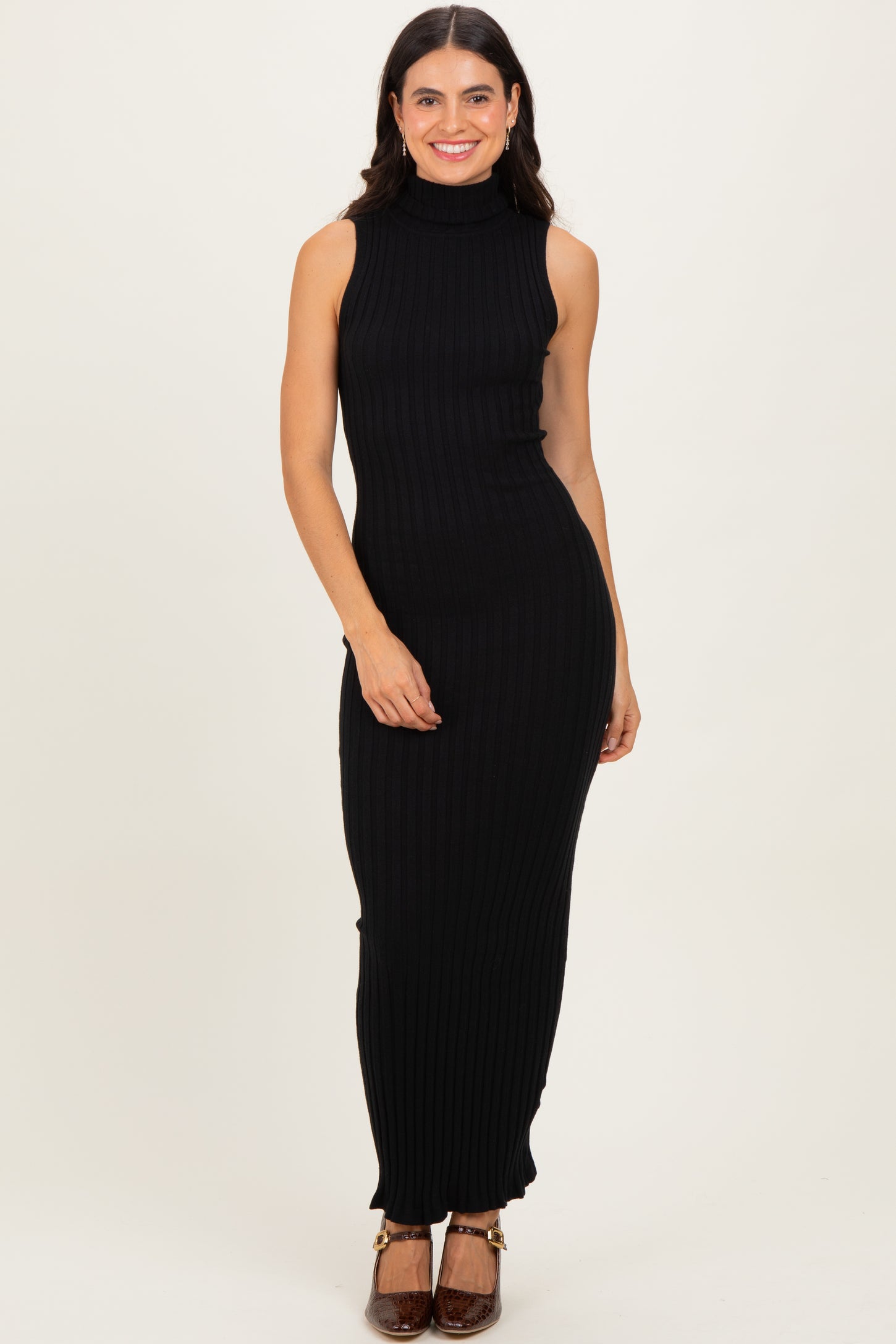 woman wearing a black ribbed sleeveless maxi dress with a turtleneck and fitted silhouette