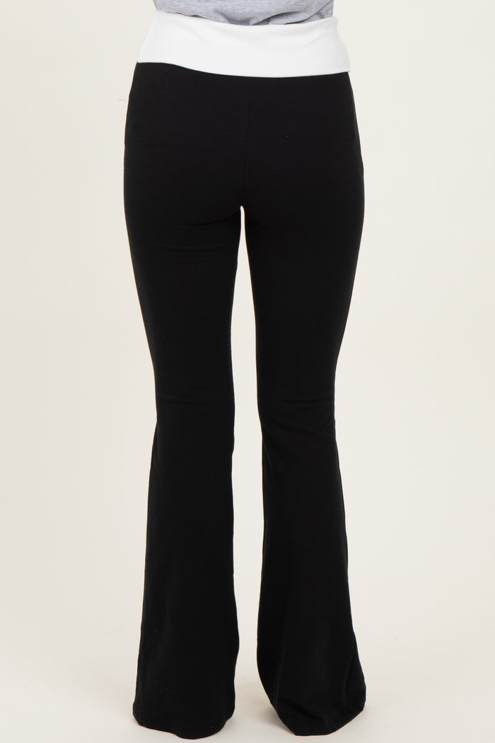 woman wearing black flared yoga pants with a white waistband, seen from the back