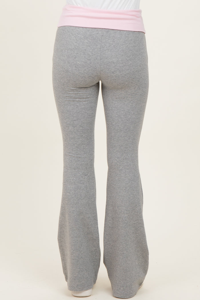 woman wearing gray flared yoga pants with a pink waistband, viewed from the back