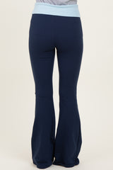 woman wearing navy blue flared yoga pants with a light blue waistband, viewed from the back