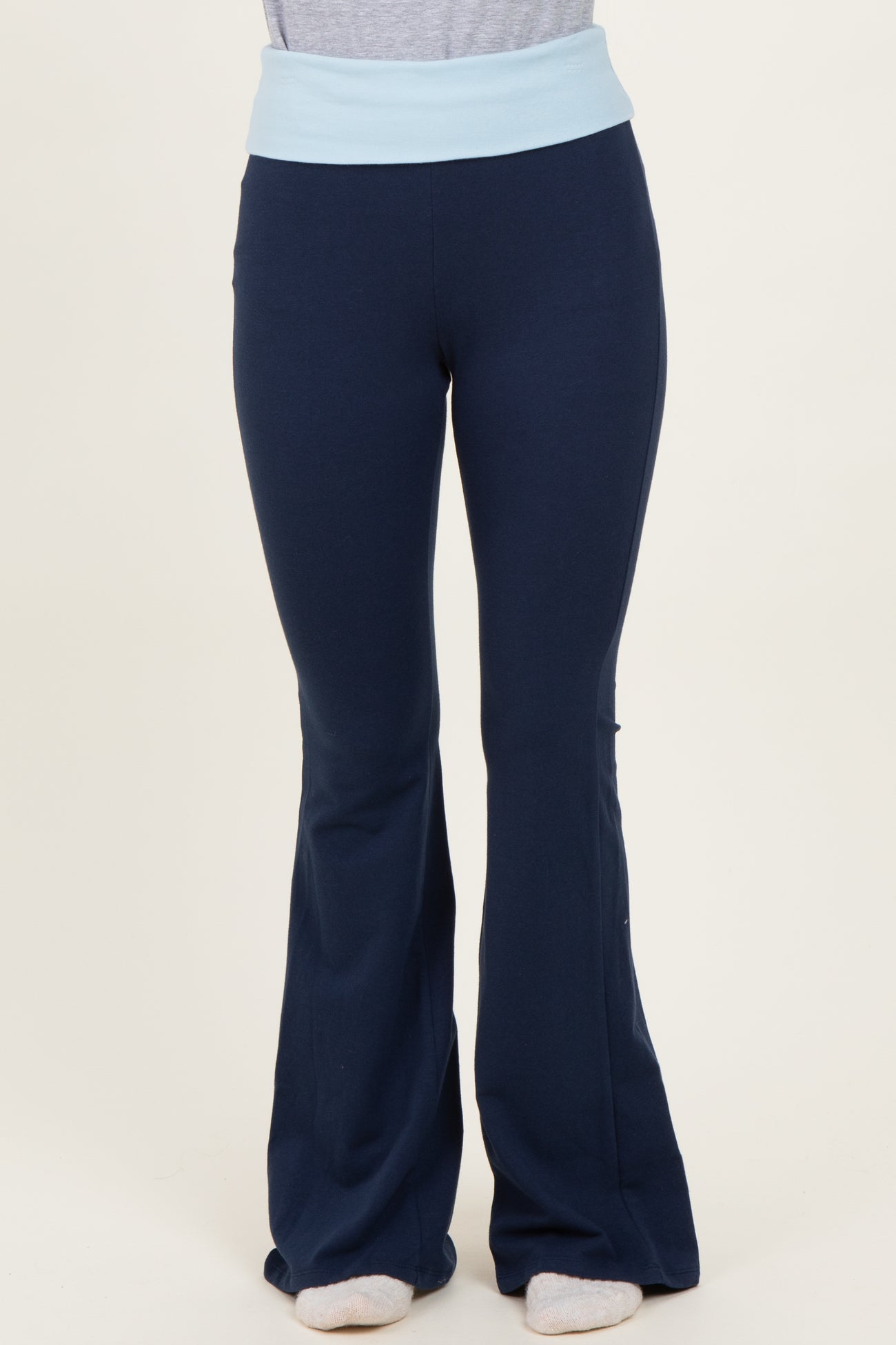 woman wearing navy blue flared yoga pants with a light blue waistband