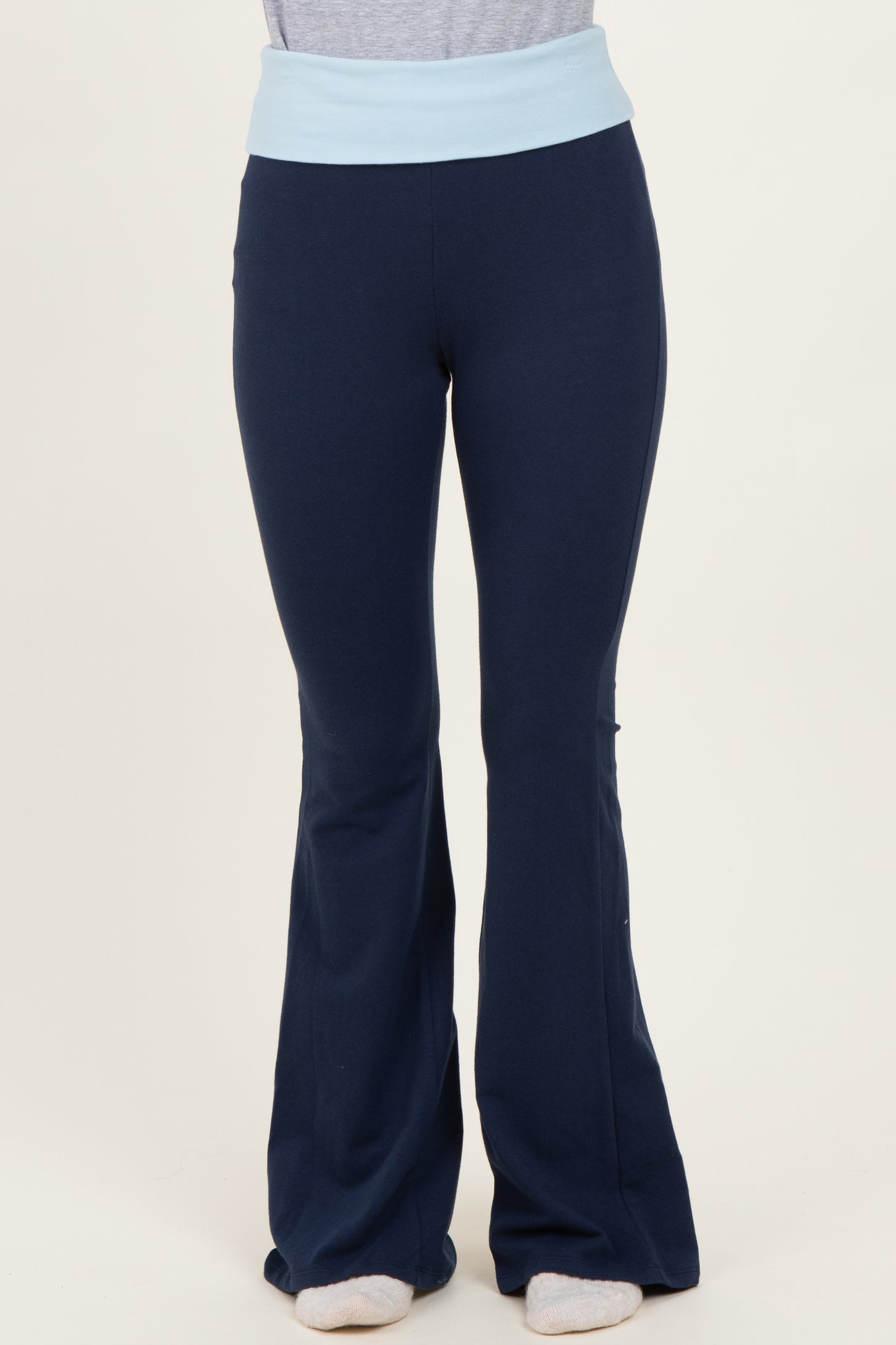 woman wearing navy blue flared yoga pants with a light blue waistband
