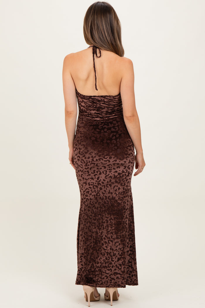 woman wearing a brown maternity maxi dress with a leopard print and halter neck style, showing her pregnant belly
