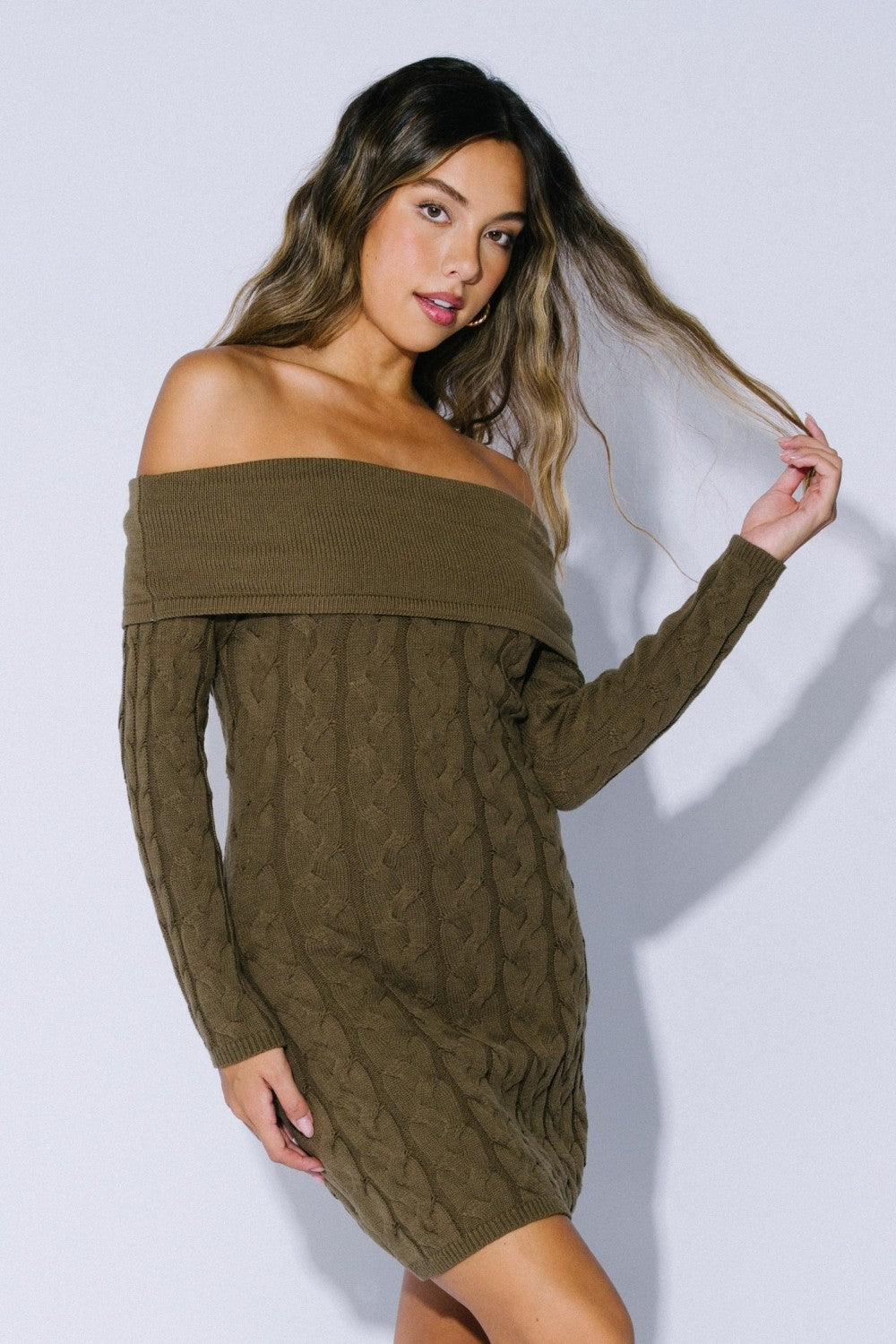 woman wearing an olive green off-the-shoulder cable knit sweater dress with long sleeves