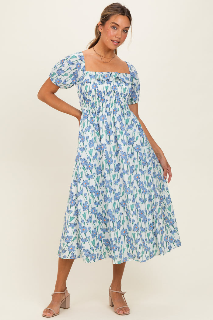 woman wearing a blue and white floral midi dress with puff sleeves and a square neckline