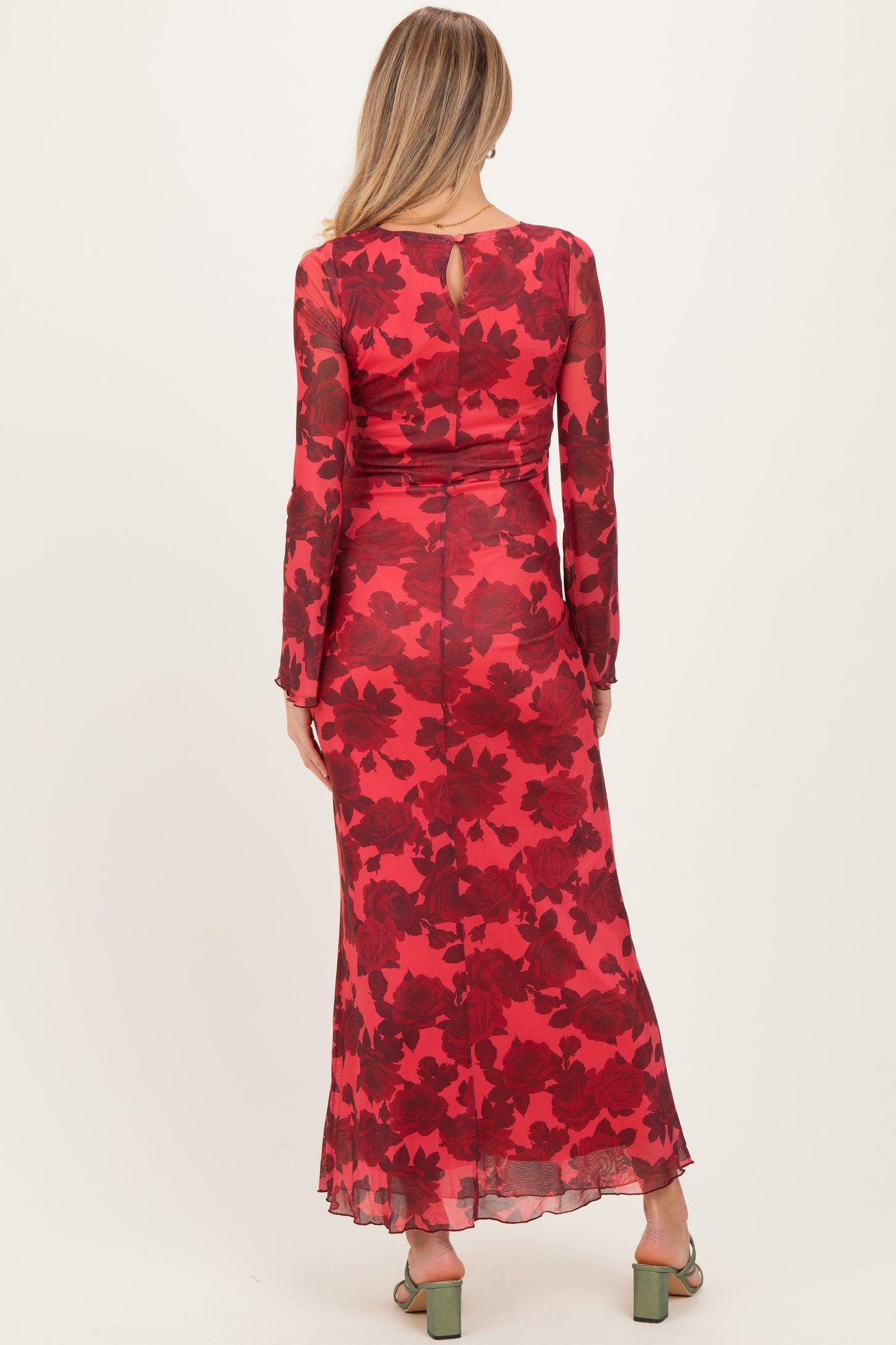 woman wearing a red floral patterned maternity maxi dress with long sleeves and a keyhole back detail