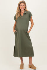 woman wearing an olive green maternity dress with a collar, short sleeves, and side pockets, model showing baby bump