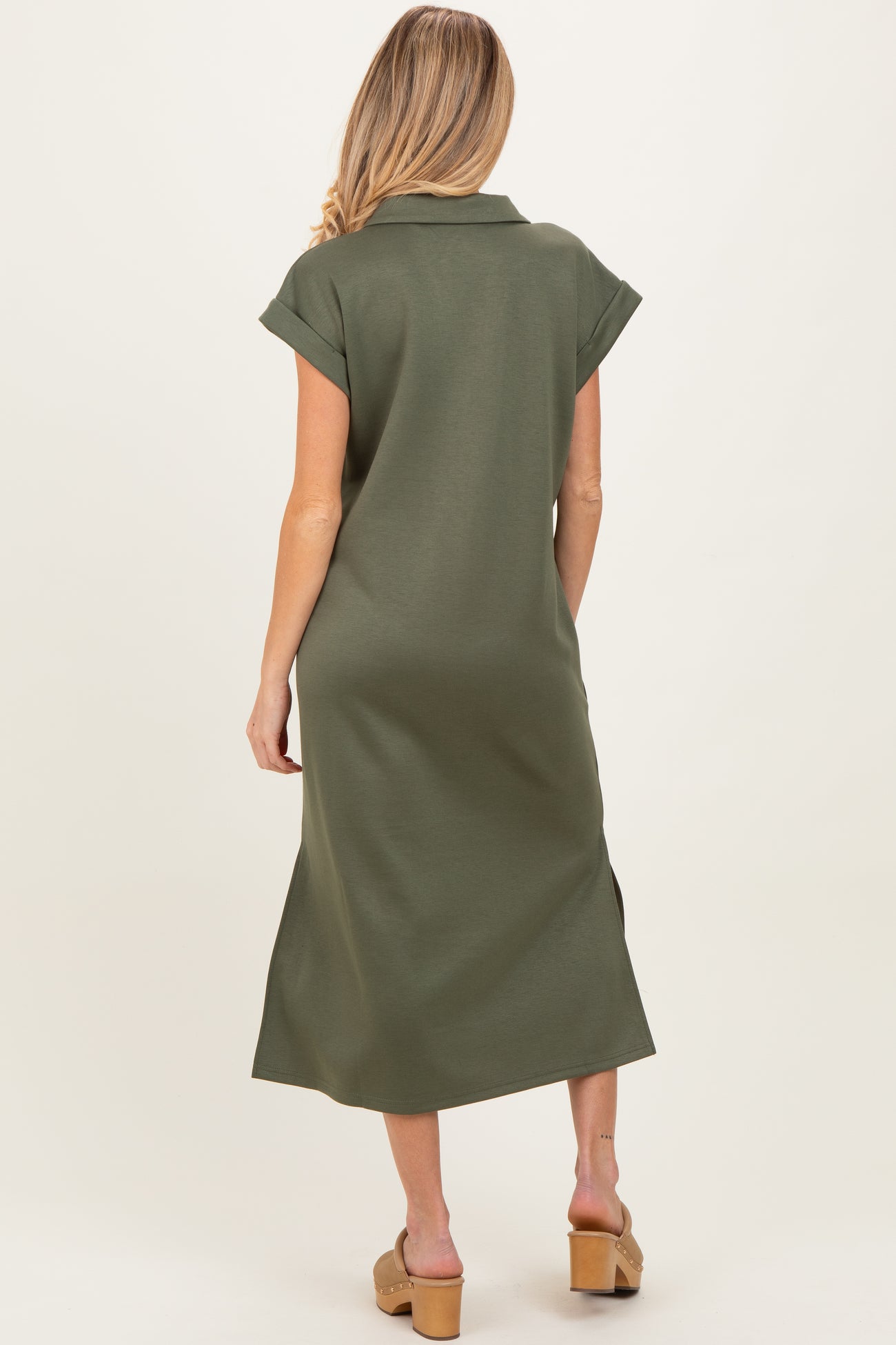 woman wearing a dark green maternity dress with a collar and short sleeves, viewed from the back