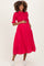 woman wearing a bright pink short sleeve maternity dress with buttons and holding her baby bump
