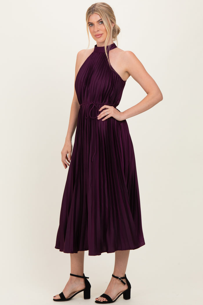 woman wearing a plum pleated midi dress with a halter neckline and tie waist detail