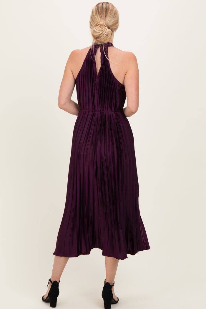 woman wearing a burgundy pleated halter neck midi dress, shown from the back