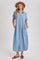 woman wearing a light blue short sleeve button-up maxi dress with a pocket and side pockets, paired with a tan hat and sandals