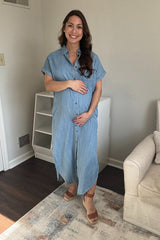 woman wearing a light denim maternity maxi shirt dress and holding her baby bump