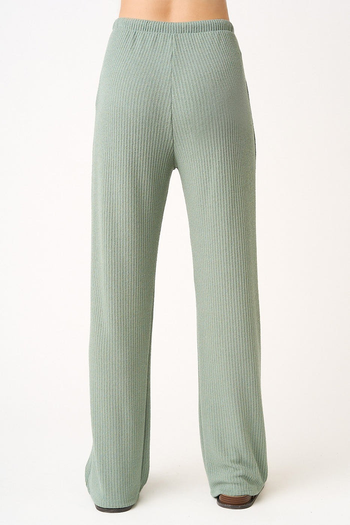 woman wearing light green ribbed wide-leg pants, shown from the back