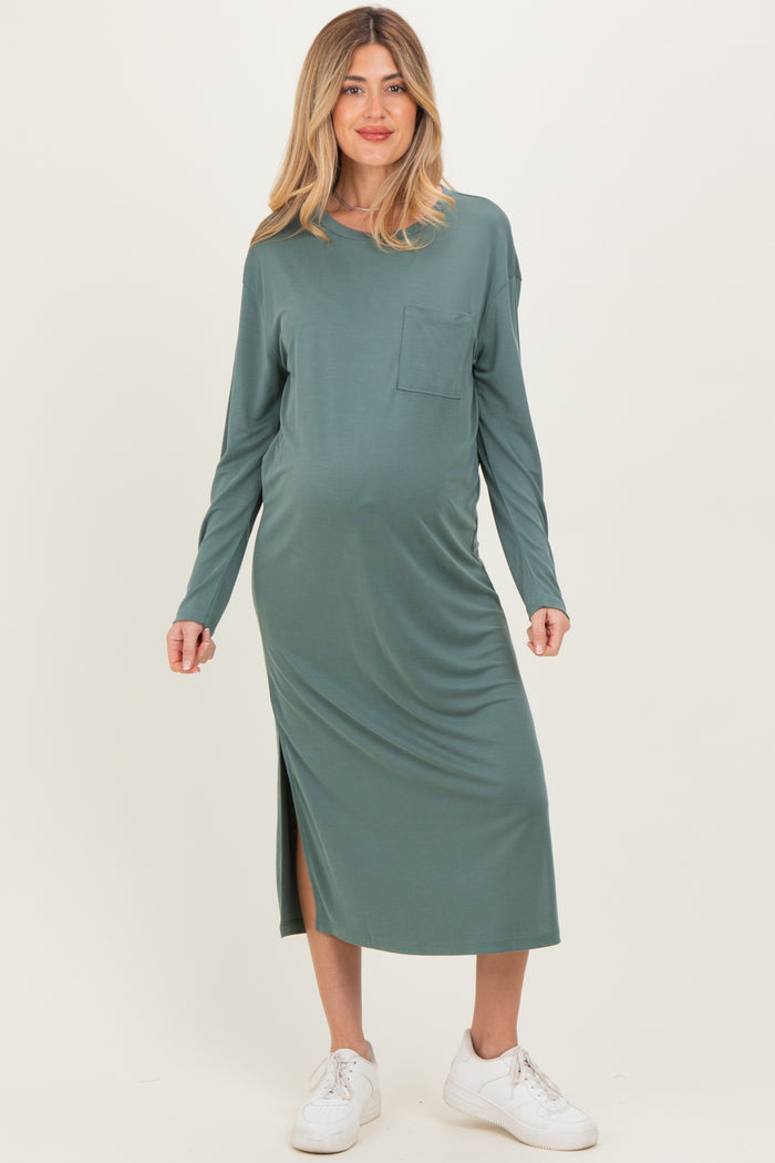 woman wearing a green long sleeve maternity dress with a side slit and pocket, showcasing her baby bump