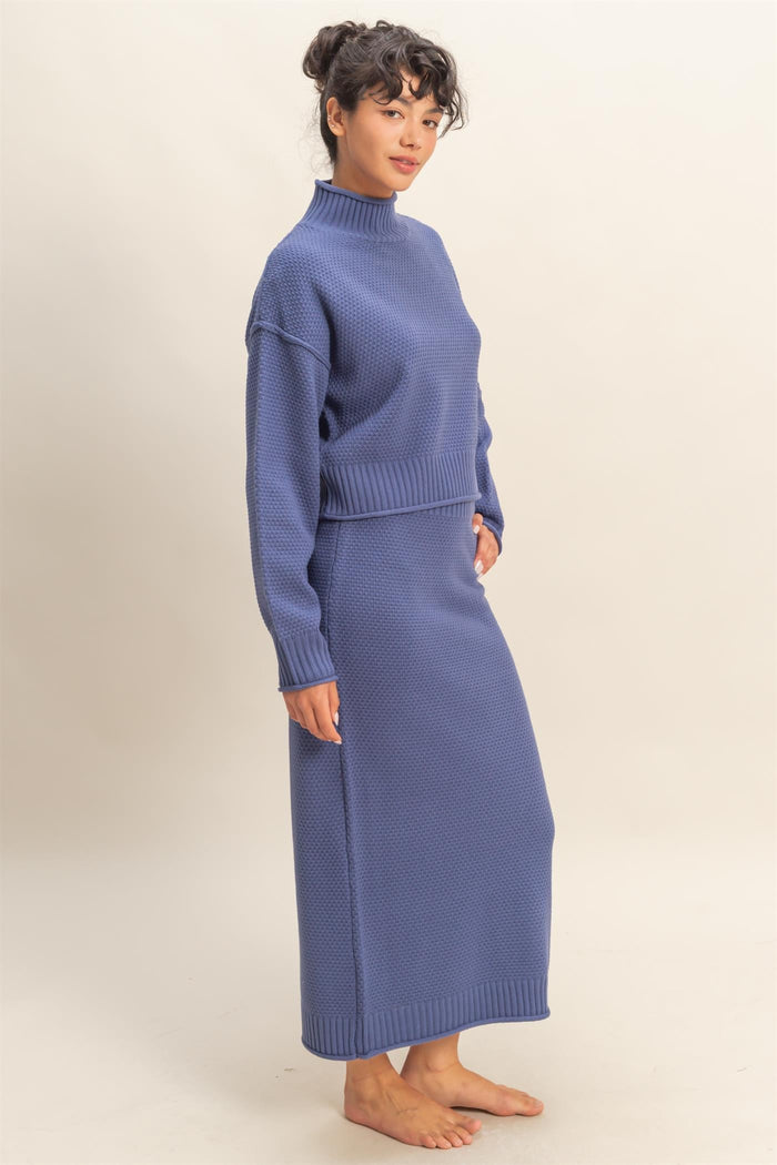 woman wearing a casual purple two-piece sweater and skirt set with a high neckline and knitted texture