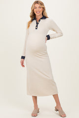 woman wearing a cream long sleeve maternity dress with a navy collar and buttons, showing her baby bump