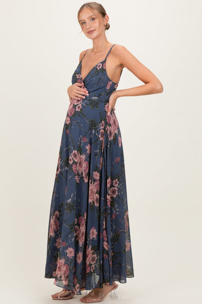 woman wearing a navy floral maternity dress with a deep v-neck and flowing skirt, showcasing her baby bump