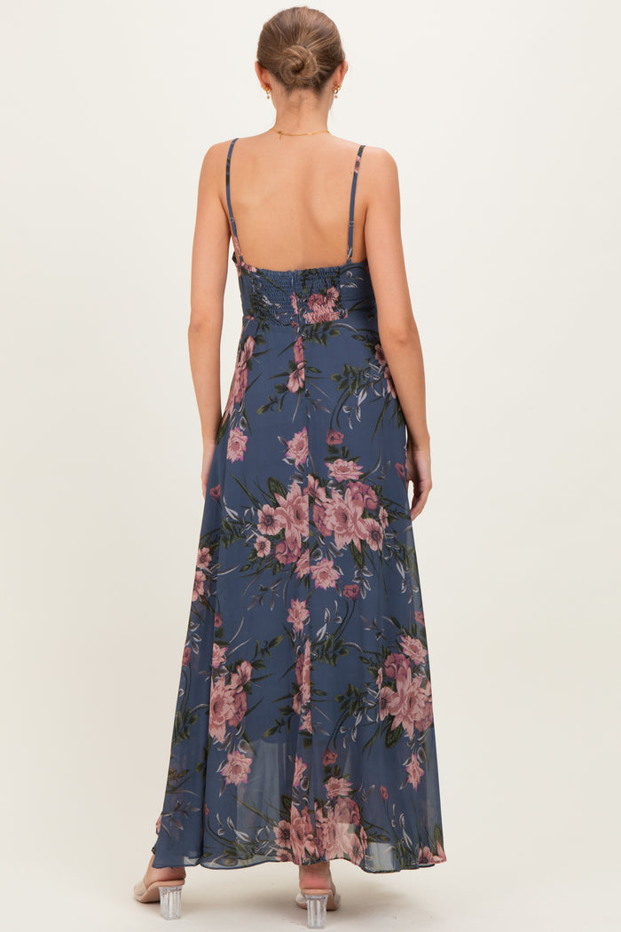 woman wearing a maternity floral maxi dress with adjustable spaghetti straps, showcasing a smocked back design