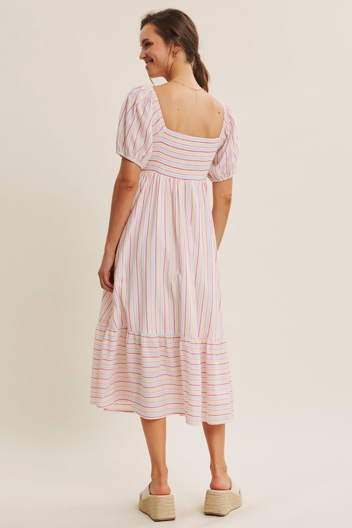 woman wearing a white and pink striped midi dress with puff sleeves and a smocked back detail