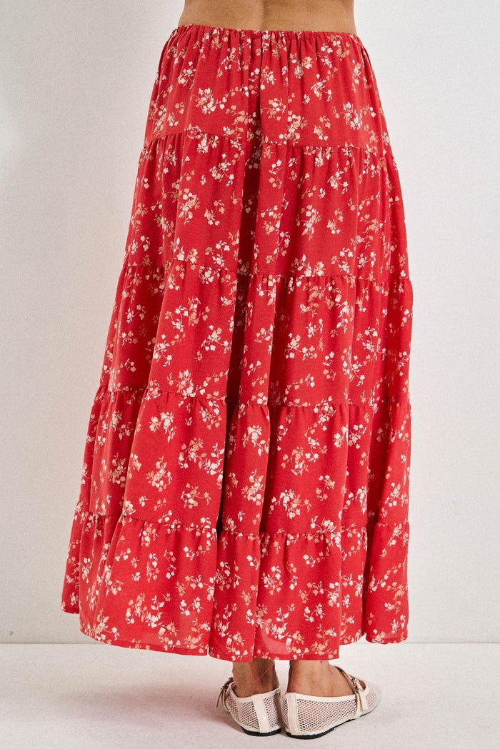 woman wearing a flowy red floral tiered maxi skirt with a comfortable elastic waistband and sandals
