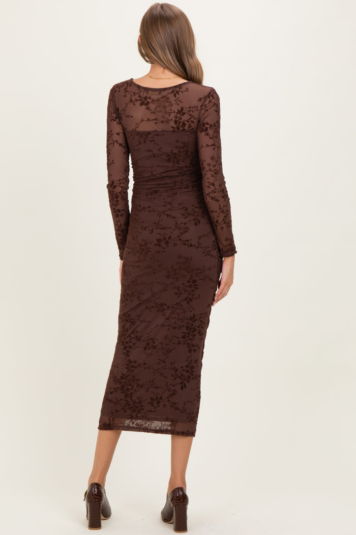 woman wearing a brown floral embroidered maternity dress with long sleeves and a fitted silhouette