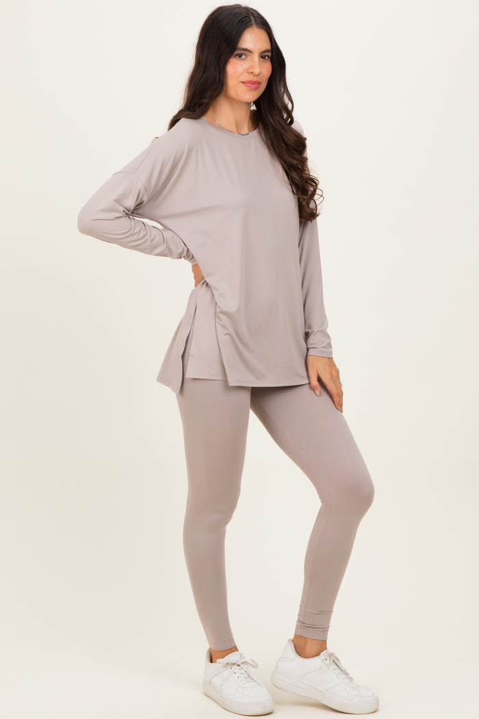 woman wearing a light taupe long sleeve top with side slits and matching leggings, styled with white sneakers