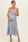 woman wearing a light blue floral maternity maxi dress, holding her baby bump