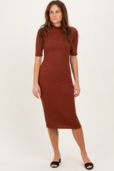 woman wearing a rust-colored ribbed midi dress with short sleeves and a fitted silhouette