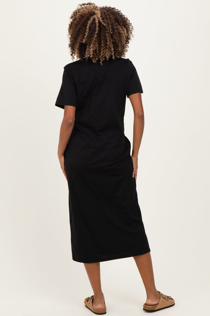 woman wearing a black short sleeve maternity dress, viewed from the back, with a flowing midi length