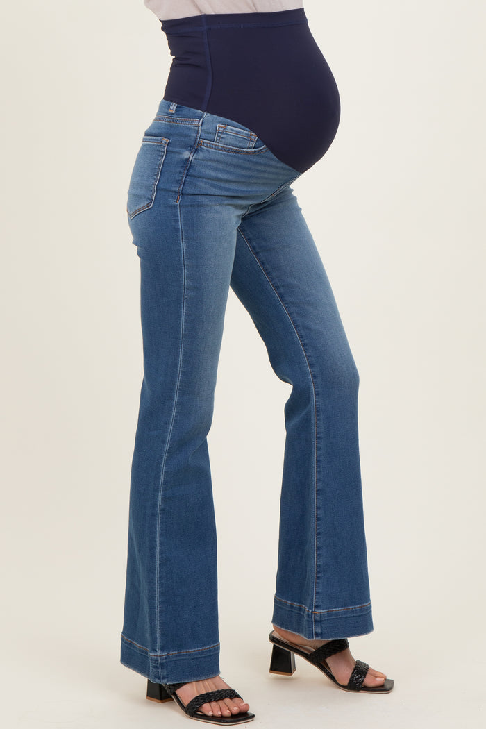 woman wearing blue maternity bootcut jeans with a navy belly panel and showing her baby bump