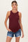 woman wearing a burgundy ribbed maternity tank top and denim shorts with a visible baby bump