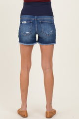 woman wearing dark wash distressed maternity denim shorts with frayed hems and a comfortable waistband