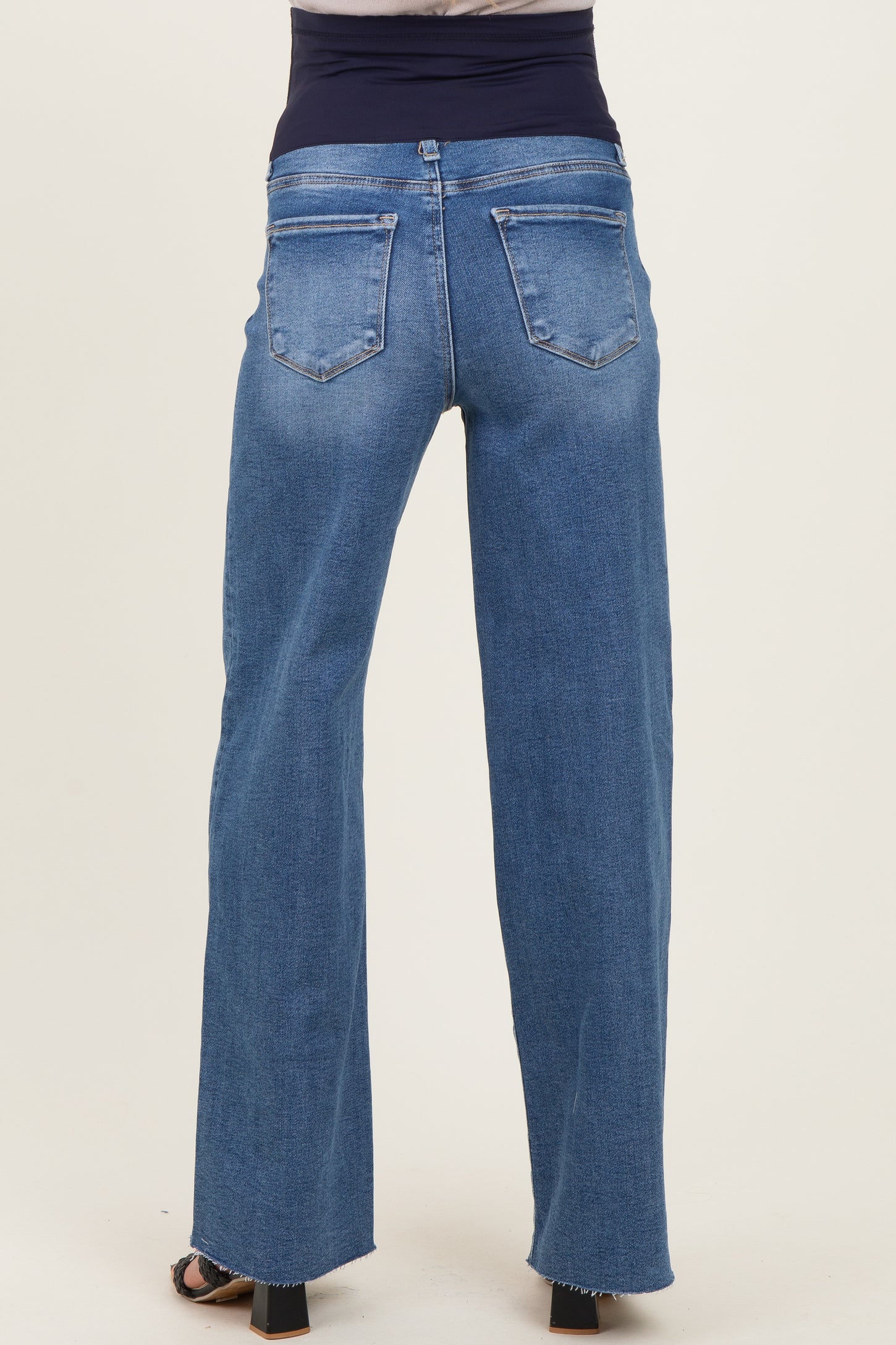 woman wearing blue maternity jeans with a high waist and wide-leg style, showing the back view