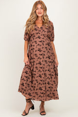 woman wearing a brown floral print maternity dress with a v-neck and puff sleeves, showing her baby bump